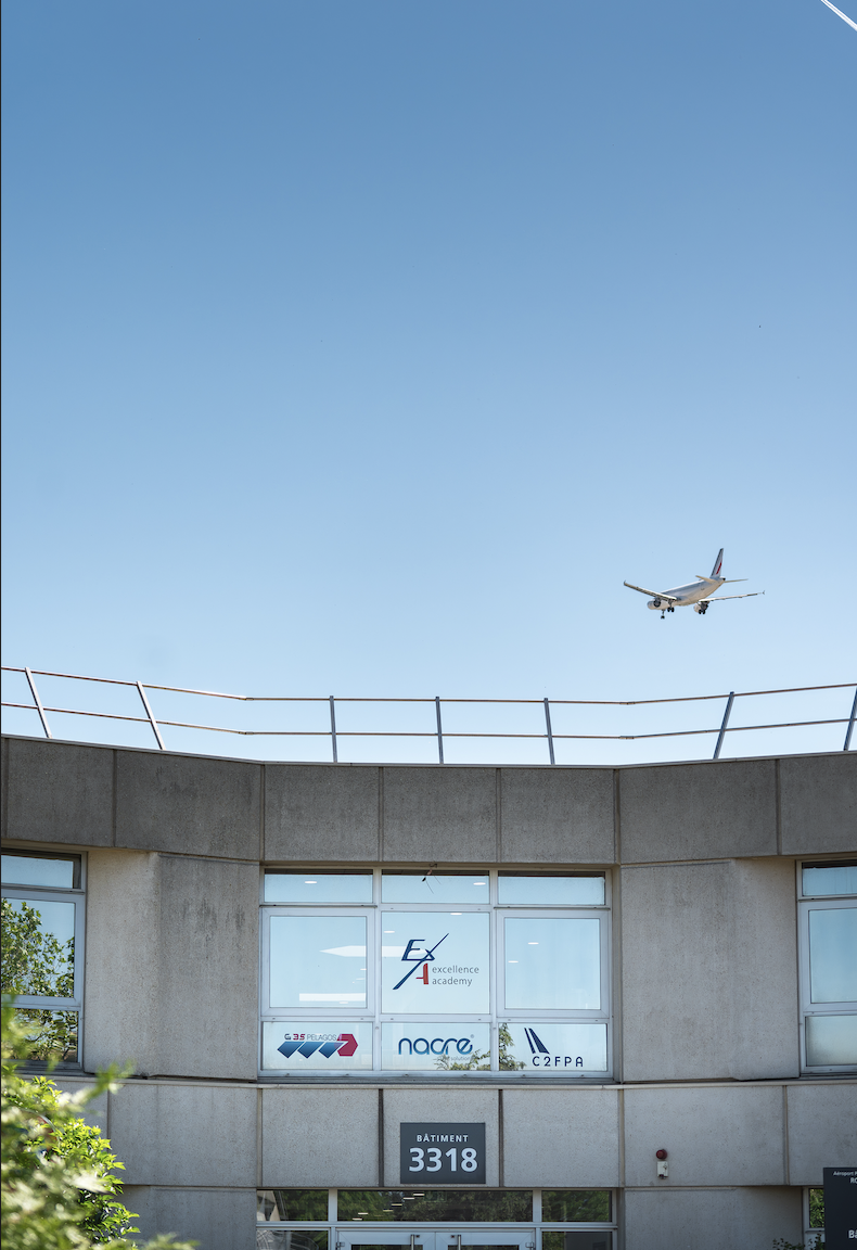 Batiment du CFA avec un avion en approche de Roissy CDG